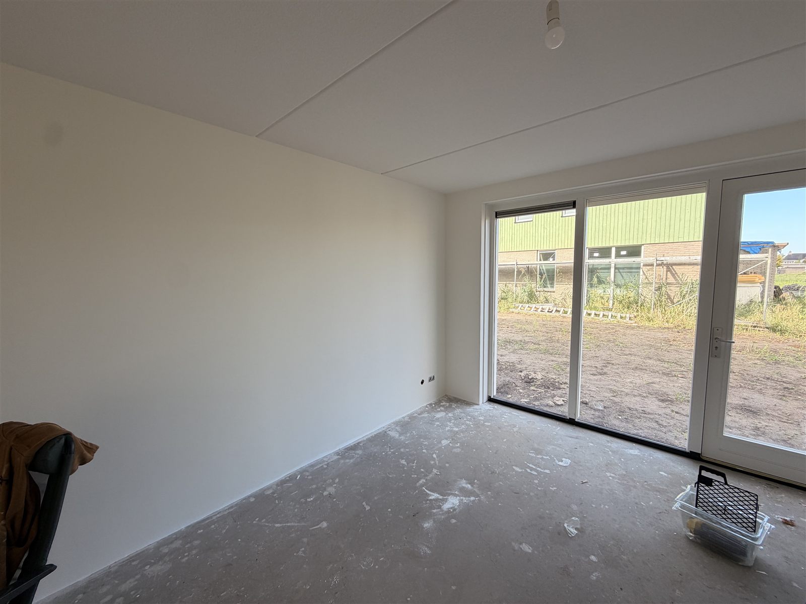 Living room with sliding doors to the garden, walls finished with renovlies and painted white